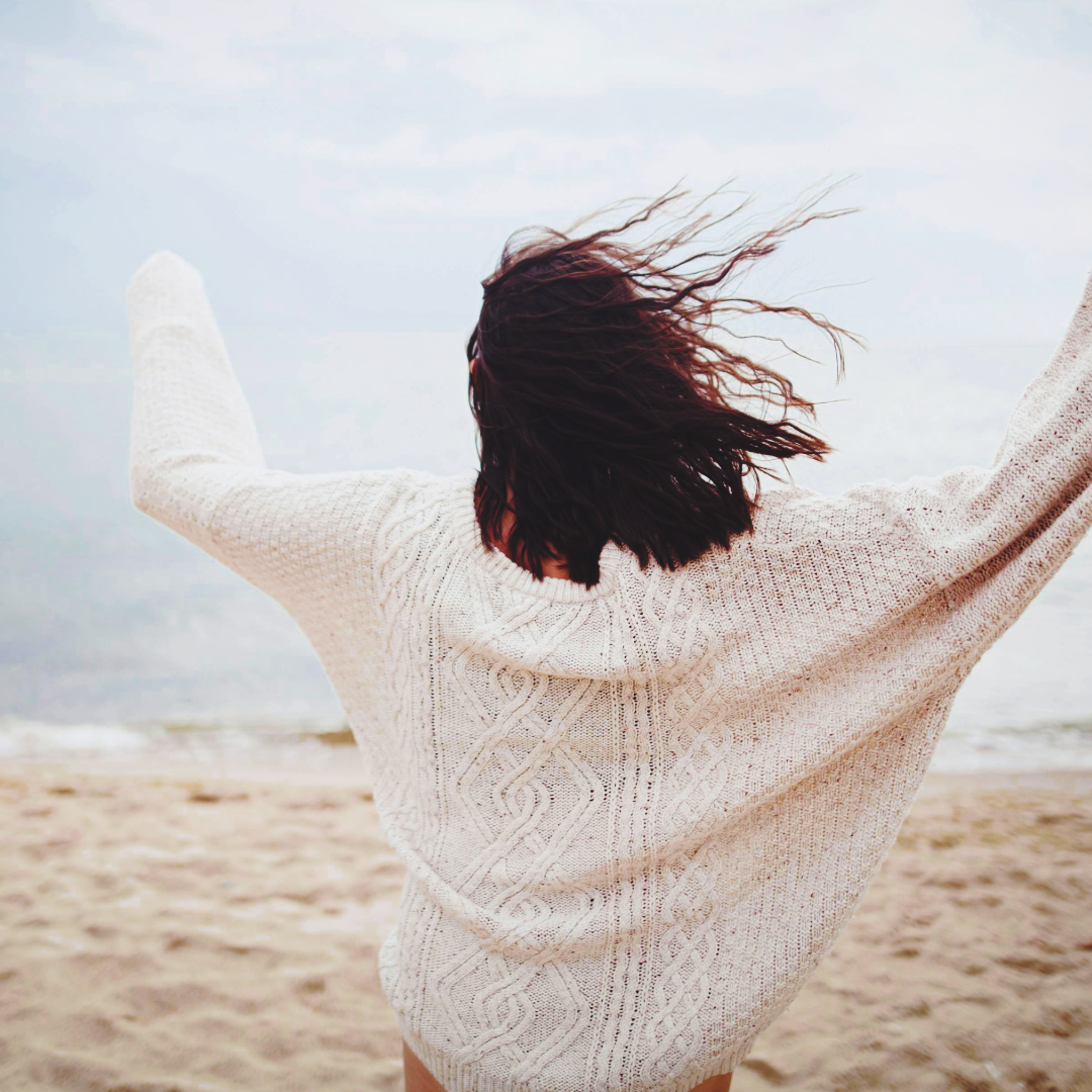 woman on the beach with her back to the camera