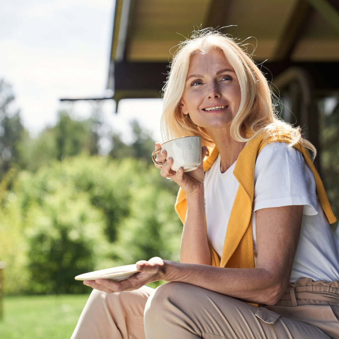 woman drinking from a teacup outside