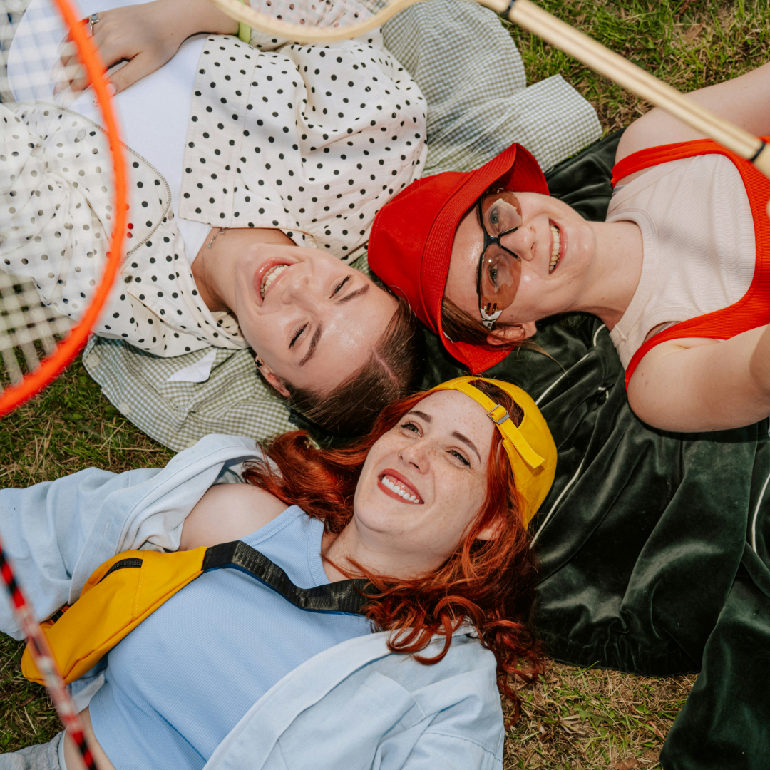 three young women laying in the grass