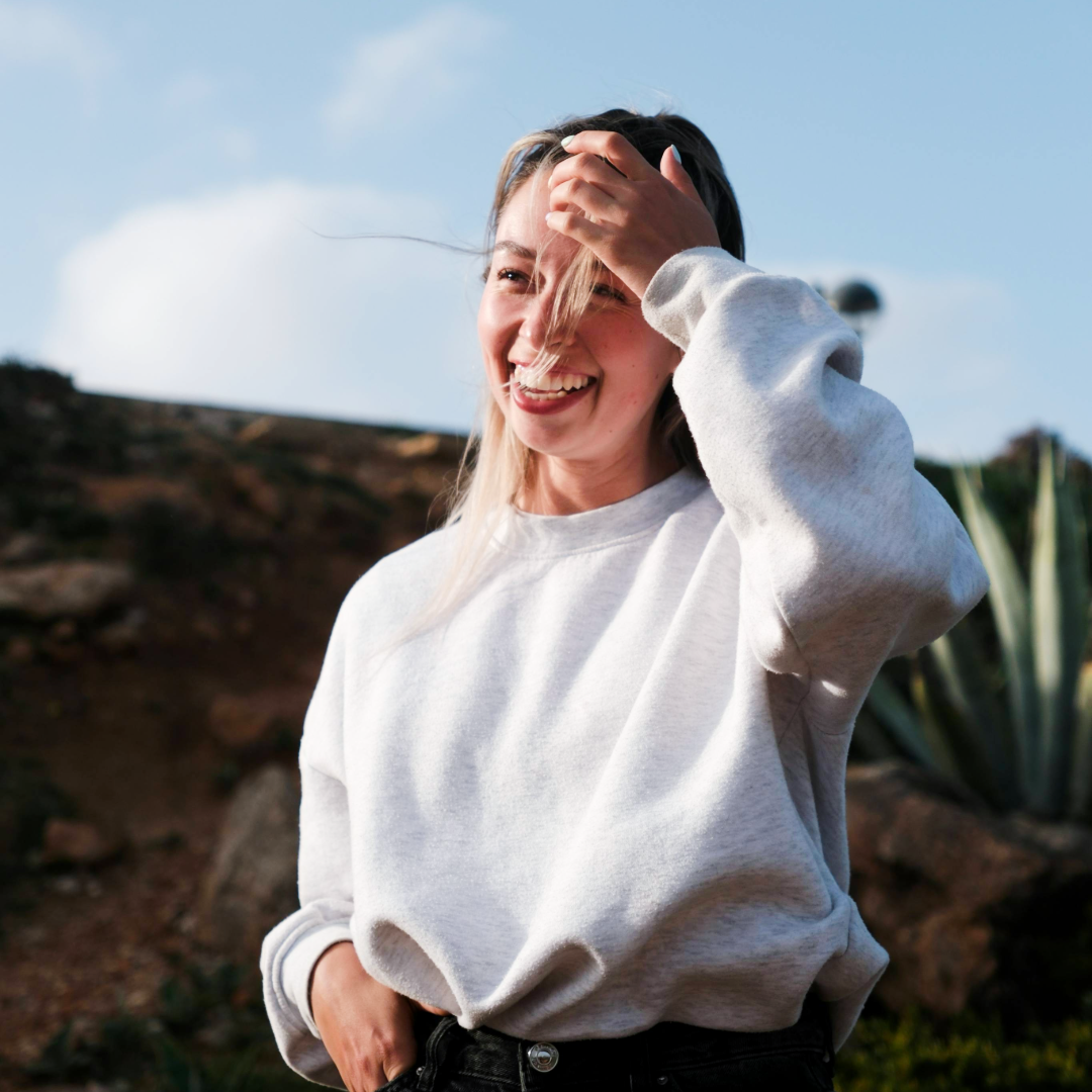 woman smiling and moving her hair off her face